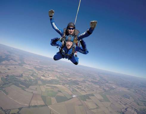 A skydiver in the air over Wiltshire county side.