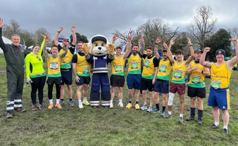 A group of runners from the Bath Half marathon, posing with a mascot 