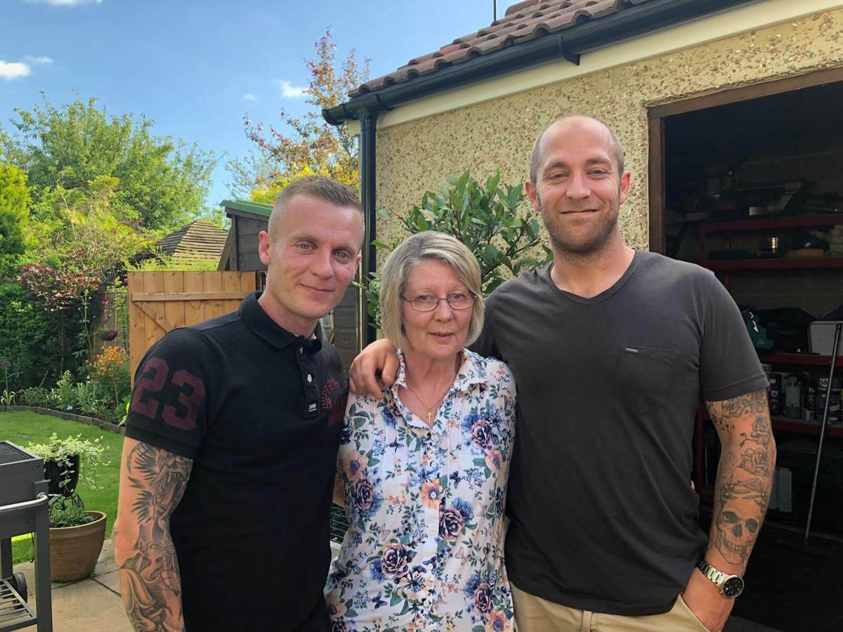 A former patient with their two children stood in a garden