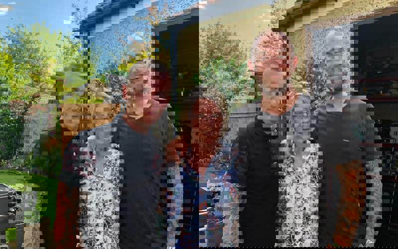 A former patient with their two children stood in a garden A former patient with their two children stood in a garden
