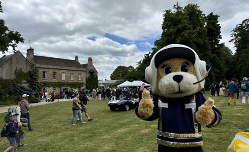 A mascot with their thumbs up in front of Middlewick House