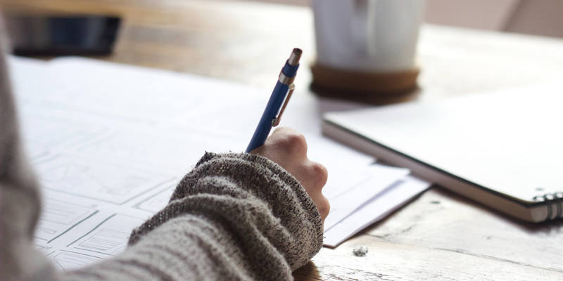 A person writing at a desk