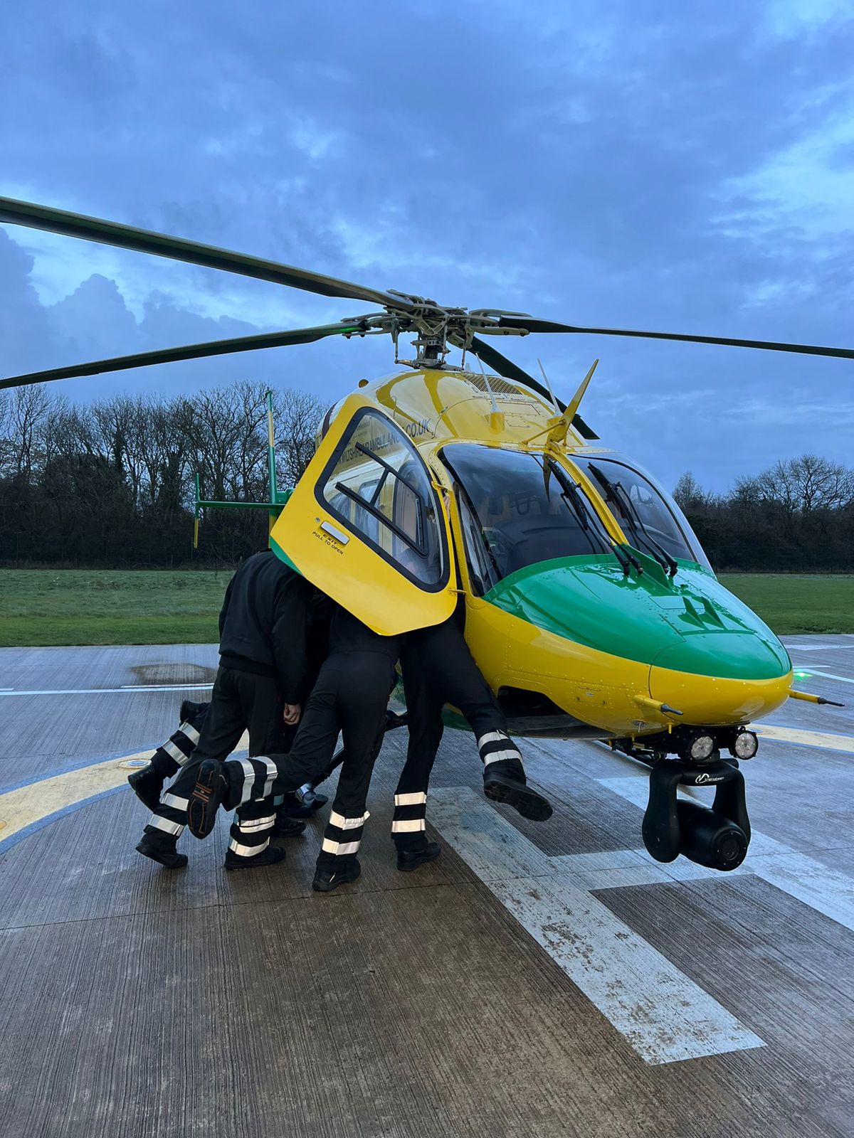 5 pilots in flight suits, all trying to get in the cockpit of a helicopter