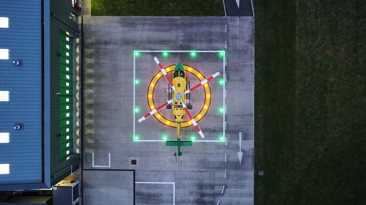 An aerial view of the WAA helicopter on a lit helipad at the charity's airbase